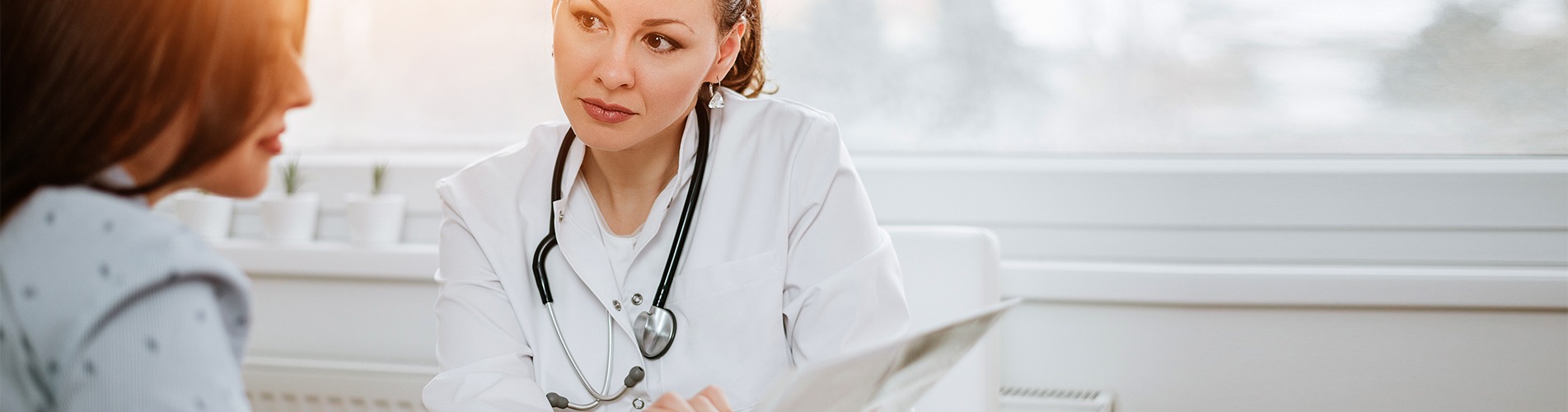 A doctor listening attentively to a woman during a medical consultation