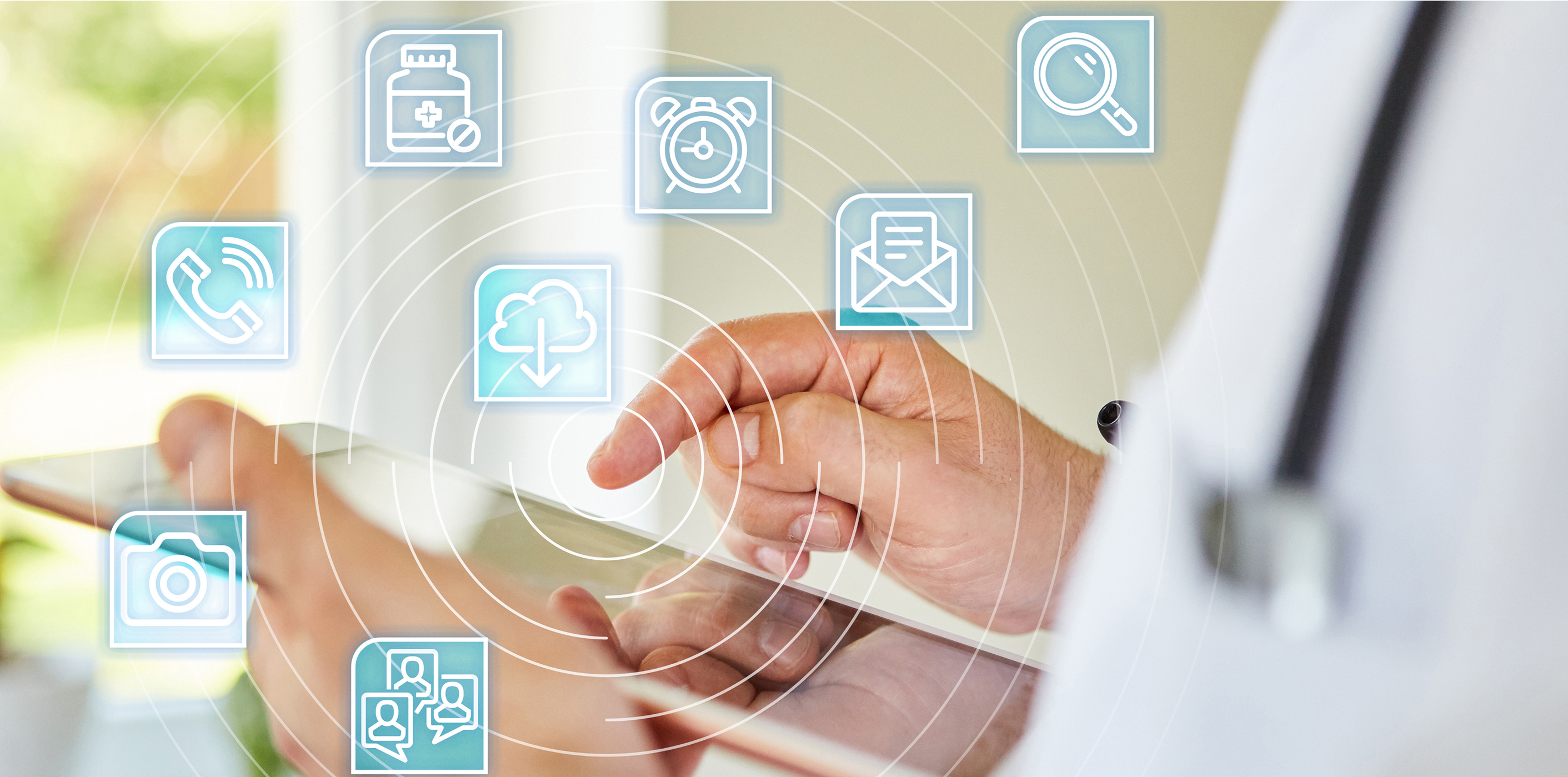 Un medico usa un tablet con icone per applicazioni sanitarie digitali – immagine simbolica della cartella informatizzata del paziente (CIP)